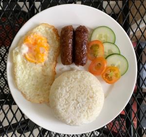 a plate of food with rice and sausage and vegetables at LS Garden Villa in Puerto Princesa City