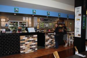 two people standing at a bar in a restaurant at Commercial Hotel Nambour in Nambour