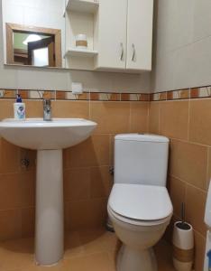 a bathroom with a white toilet and a sink at Затишна Квартира в центрі міста in Luts'k
