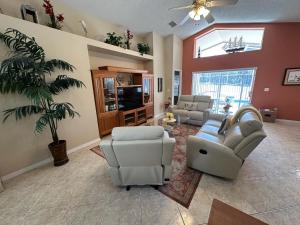a living room with couches and a palm tree at Upgraded Pool Villa Spa Southern Dunes in Haines City