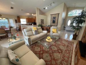 a large living room with couches and a kitchen at Upgraded Pool Villa Spa Southern Dunes in Haines City