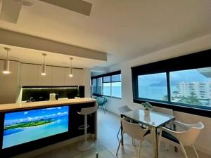 a kitchen with a dining table and a large screen tv at Altea Sound of the Sea in Altea