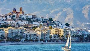 a sail boat in the water in front of a city at Altea Sound of the Sea in Altea