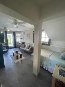 a bedroom with a bed and a living room at Scarlett Studios 3-US Embassy 7 mins drive- Lloyd Erskine Sandiford Centre & Ross university 5 mins drive-Only a 1 night reservation includes airport and embassy round trip in Bridgetown