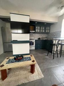 a kitchen with a table with a bowl of fruit on it at Scarlett Studios 3-US Embassy 7 mins drive- Lloyd Erskine Sandiford Centre & Ross university 5 mins drive-Only a 1 night reservation includes airport and embassy round trip in Bridgetown