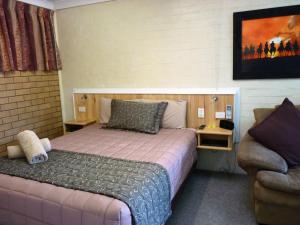 a small bedroom with a bed and a couch at Winchester Motel in Moree