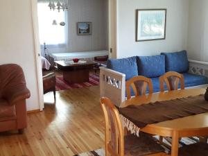 a living room with a blue couch and a table at Maatilamajoitus in Ylihärmä