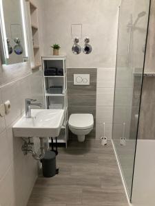 une salle de bain avec toilettes, lavabo et douche dans l'établissement Ferienwohnungen Garzke, à Neustadt