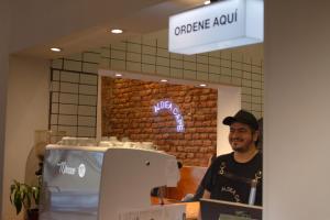 a man standing in front of a counter in a store at Aldea Hostel & Café in Cordoba