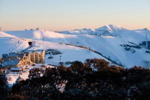 a resort in the snow with mountains in the background at Red Robin in Mount Hotham