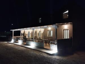 a house lit up at night with a table and chairs at Imeros house 3 in Ímeros
