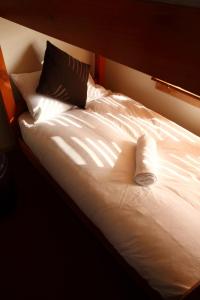 a bed with white sheets and two pillows on it at Sanki in Mount Hotham