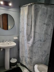 ein Bad mit einem Marmorduschvorhang und einem Waschbecken in der Unterkunft Alquiler Temporario en Nueva Córdoba! in Cordoba + 35 Fotos