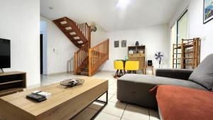 a living room with a couch and a table at Maison Calme aux Avirons in Les Avirons +12 photos
