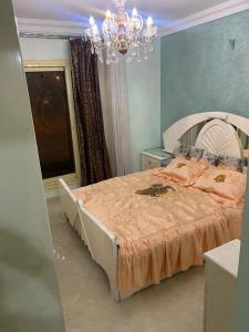 a bedroom with a large bed with a chandelier at Khamayel compound in Kafr Abū ʼumaydah