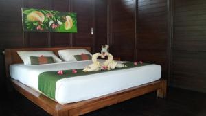 a bedroom with two swans on a bed at Radya Homestay in Nusa Lembongan