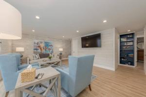 a living room with blue chairs and a tv at Sunset Family Villa C2 in Bridgman +2 photos