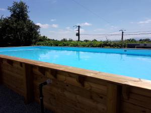 a large blue swimming pool with a wooden fence around it at Pyrenees Vue Gite - Vues Fantastique, Parking Gratuit Sur Place & Piscine in Saint-Gaudens