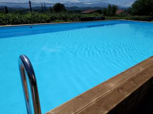 a large blue swimming pool with a wooden railing at Pyrenees Vue Gite - Vues Fantastique, Parking Gratuit Sur Place & Piscine in Saint-Gaudens
