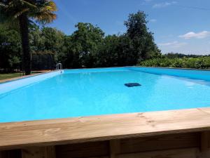 a large blue swimming pool with a wooden deck at Pyrenees Vue Gite - Vues Fantastique, Parking Gratuit Sur Place & Piscine in Saint-Gaudens