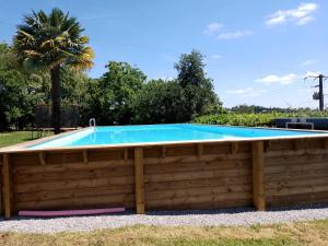 a swimming pool with a wooden fence around it at Pyrenees Vue Gite - Vues Fantastique, Parking Gratuit Sur Place & Piscine in Saint-Gaudens