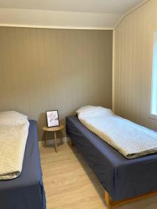 a room with two beds and a table with a picture at 2 etasje leilighet med 2 soverom in Harstad