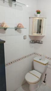 een witte badkamer met een toilet en een spiegel bij Bungalow Playa Flamenca in Orihuela