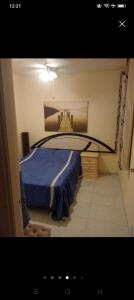 een slaapkamer met een bed met een blauwe deken bij Bungalow Playa Flamenca in Orihuela