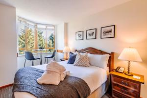 Un dormitorio con una cama y una mesa y sillas. en Cascade by Elevate Vacations, en Whistler