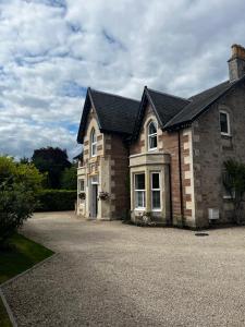 a large brick house with a large driveway at Beinn Mhor Lodge, 63 Culduthel Road in Inverness