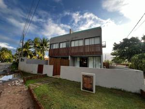a building with a sign in front of it at Villa Mutum - Triplex na Rota Ecológica dos Milagres Praia do Patacho in Pôrto de Pedras