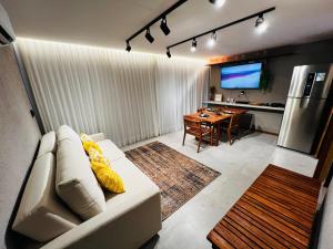 a living room with a white couch and a table at Villa Mutum - Triplex na Rota Ecológica dos Milagres Praia do Patacho in Pôrto de Pedras