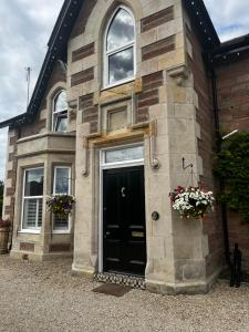 a brick house with a black door and two windows at Beinn Mhor Lodge, 63 Culduthel Road in Inverness +19 photos