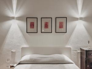 a bedroom with three pictures on a wall with a bed at New Design Ortigia in Siracusa