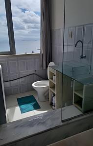 um banheiro com vaso sanitário, pia e janela em Apartamento com ar-condicionado em Salvador