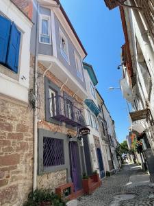 a building with purple doors on a street at Almina Kantarcı Pansiyon in Ayvalık