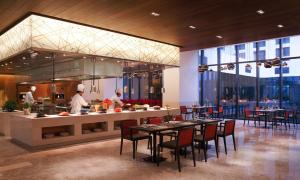 a restaurant kitchen with tables, chairs, and tables at Novotel New Delhi Aerocity- International Airport in New Delhi