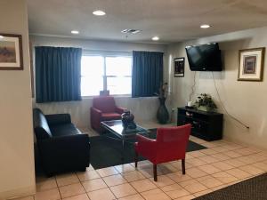 a living room with two chairs and a tv at Chadron Inn & Suites in Chadron