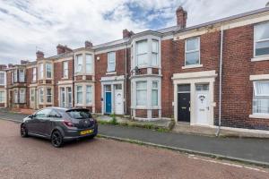 a car parked in front of a row of brick houses at Saltwell Place Gateshead in Gateshead