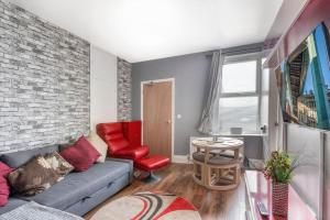 a living room with a couch and a brick wall at Saltwell Place Gateshead in Gateshead