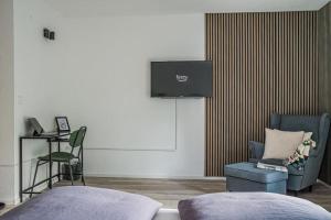 ein Schlafzimmer mit Bett, Stuhl und Fernseher in der Unterkunft KasselRooms II in Kassel