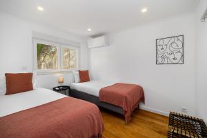 a hotel room with two beds and a window at WHome Peaceful Algés Family Home away from City Noise in Algés