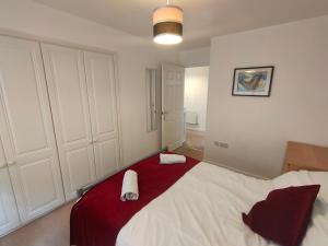 ein Schlafzimmer mit einem großen Bett mit einer roten Decke in der Unterkunft Landau House in Bristol