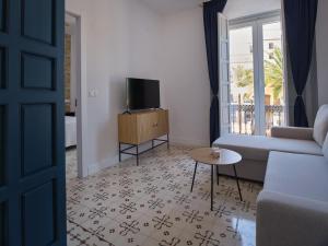 Una sala de estar con un sofá y un televisor. en V11apartamentos1, en Archidona