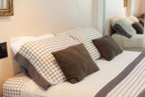 a bed with three pillows on it in a room at Shopping Piratas, vista para o mar, estacionamento in Angra dos Reis