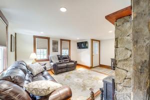 a living room with a leather couch and a stone wall at Walk to Memorial Park Pet-Friendly Bethlehem Home in Bethlehem