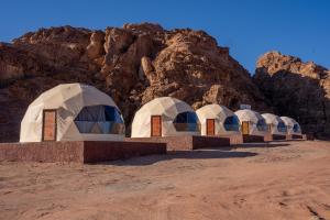 a row of domes in front of a mountain at wadi rum al omar in Disah