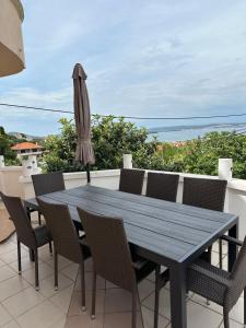 a wooden table and chairs on a balcony with an umbrella at Vila Rosa in Tkon