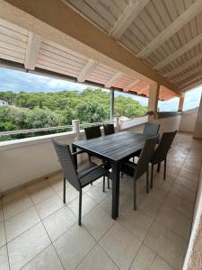 a dining room with a table and chairs on a balcony at Vila Rosa in Tkon