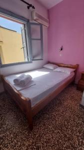a bedroom with a large bed with a window at Old town Room With Window in Rethymno
